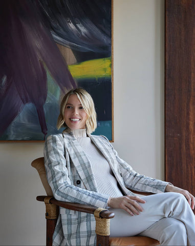 Woman sitting in a chair in a room with a painting on the wall